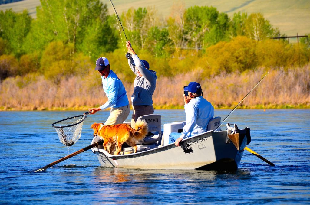 Drift boat day on a Montana river with guide, angler, and lodge dog