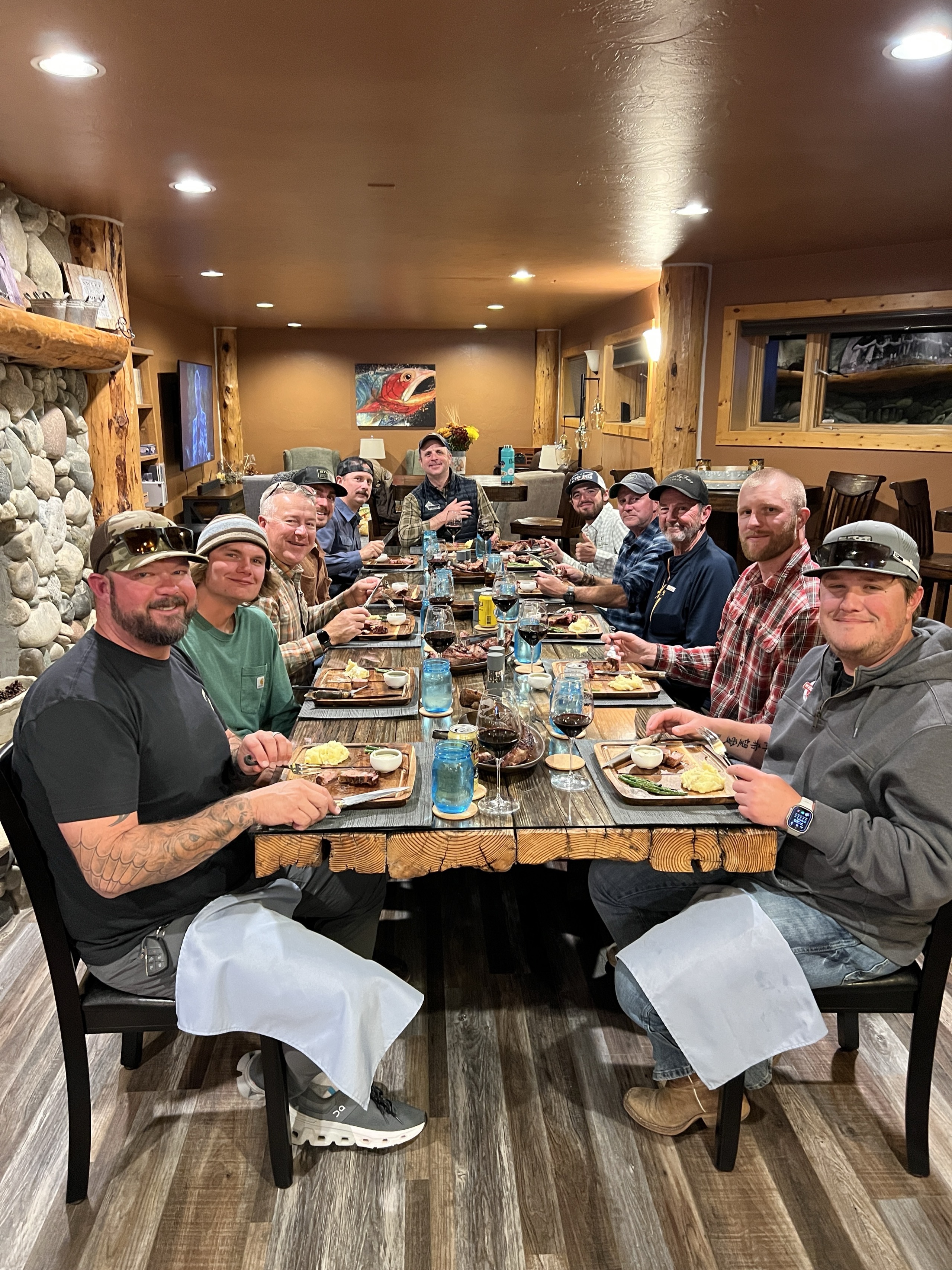 Full table enjoying steaks and wine in the lodge