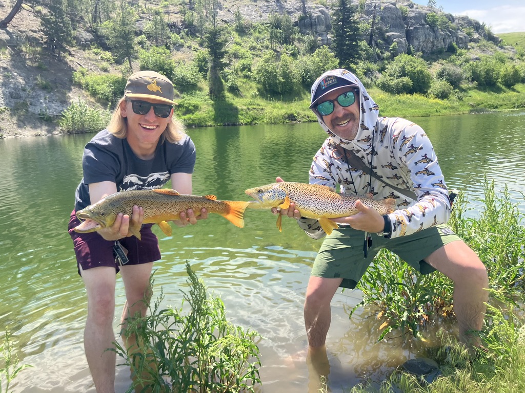 Trout pond double up — two anglers with brown trout