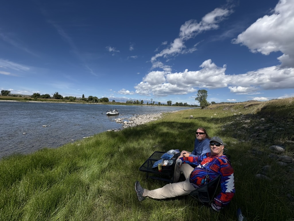 Couple enjoying a riverside lunch during their float