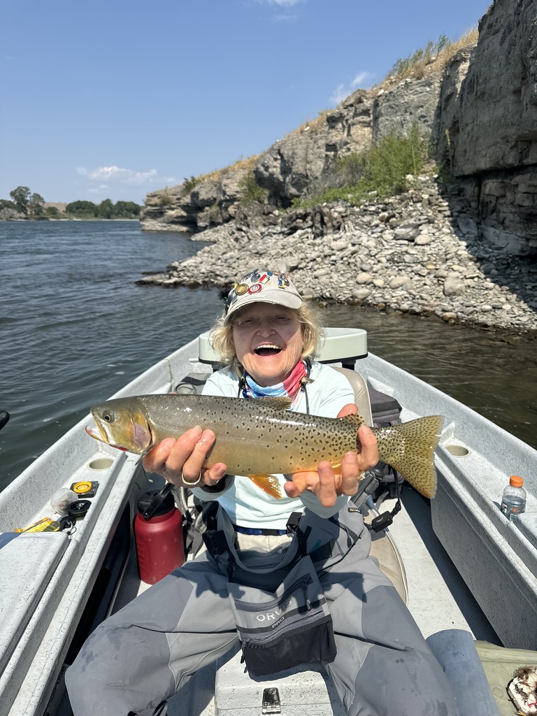 Angler with a beautiful brown trout in the boat