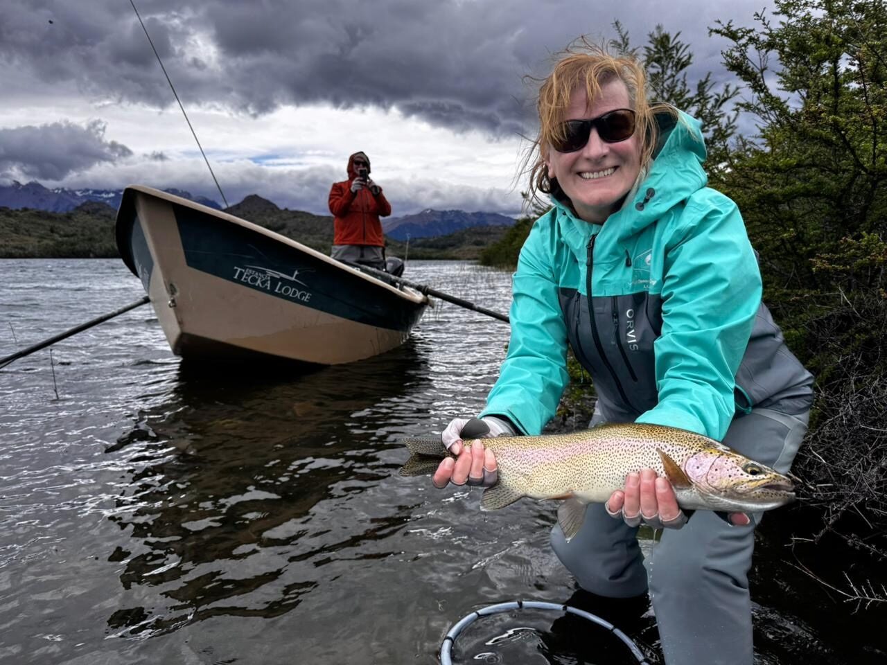 Judi Powers holding a rainbow trout on the river